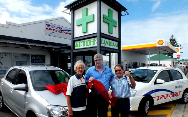 ‘n Dankbare Gerhard Roux (regs) van Franskraal, nadat hy ‘n Toyota Etios 1.5ltr van Arrie Nel Apteekgroep gewen het, met vlnr Angeline Roux (sy eggenote) en Fanie Viljoen (Apteker/Bestuurder: Gansbaai Apteek) by hom voor Gansbaai Apteek